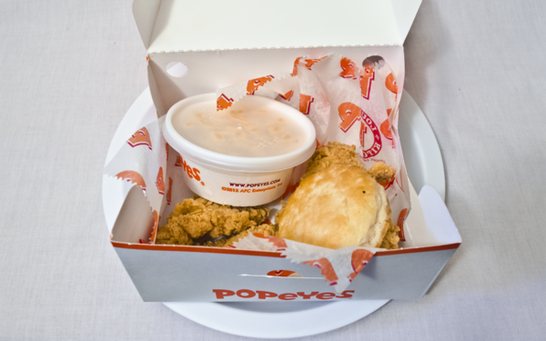 An open Popeyes box, chicken just barely visible.