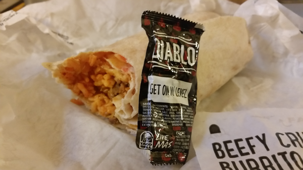 Burrito next to a packet of Diablo sauce